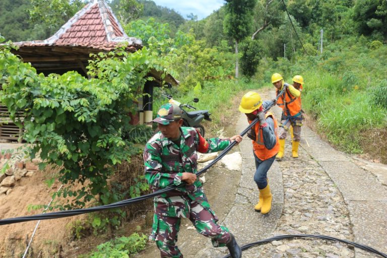 Tambah Daya Listirk Untuk Sumur Dalam, Anggota Kodim Ponorogo Bantu PLN Pasang Kabel Listrik