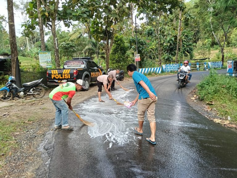 Cegah Laka Lantas, Anggota Polres Ponorogo dan Warga Bersihkan Tumpahan Solar Di Jalan Raya